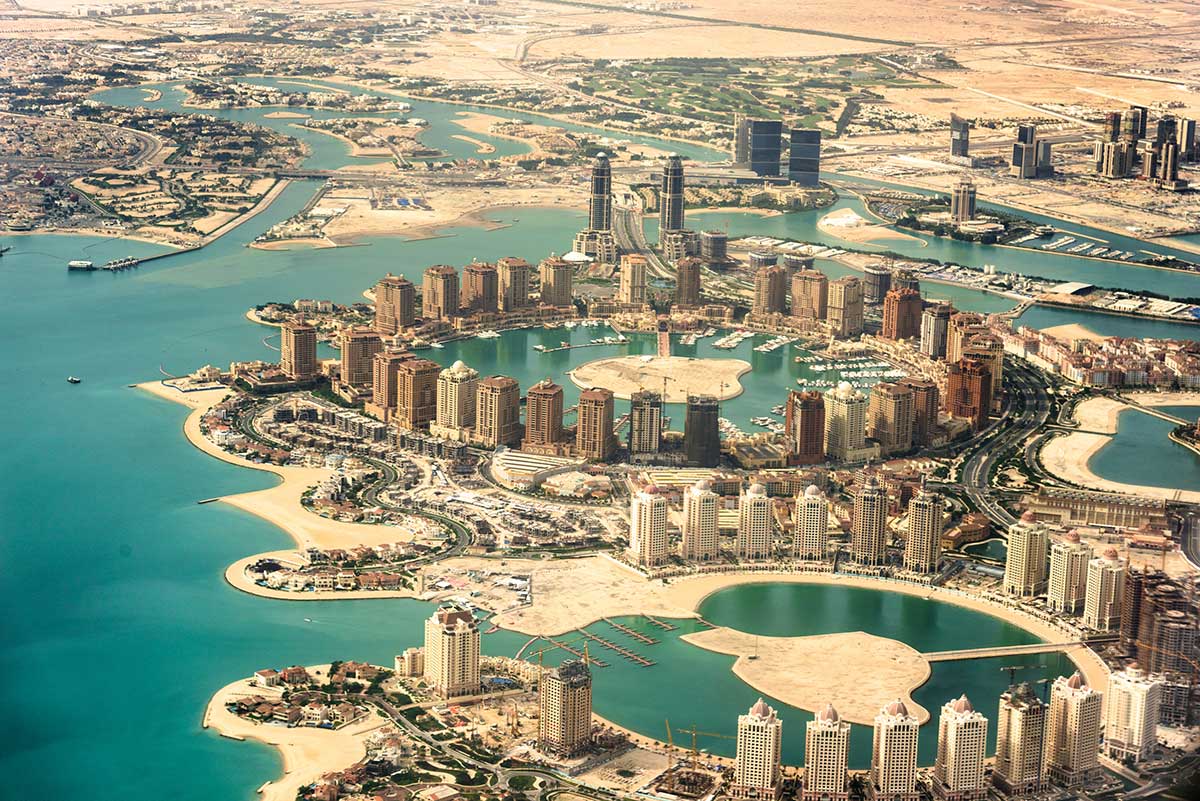 Qatar holidays from Australia — the Doha skyline across the bay at dusk