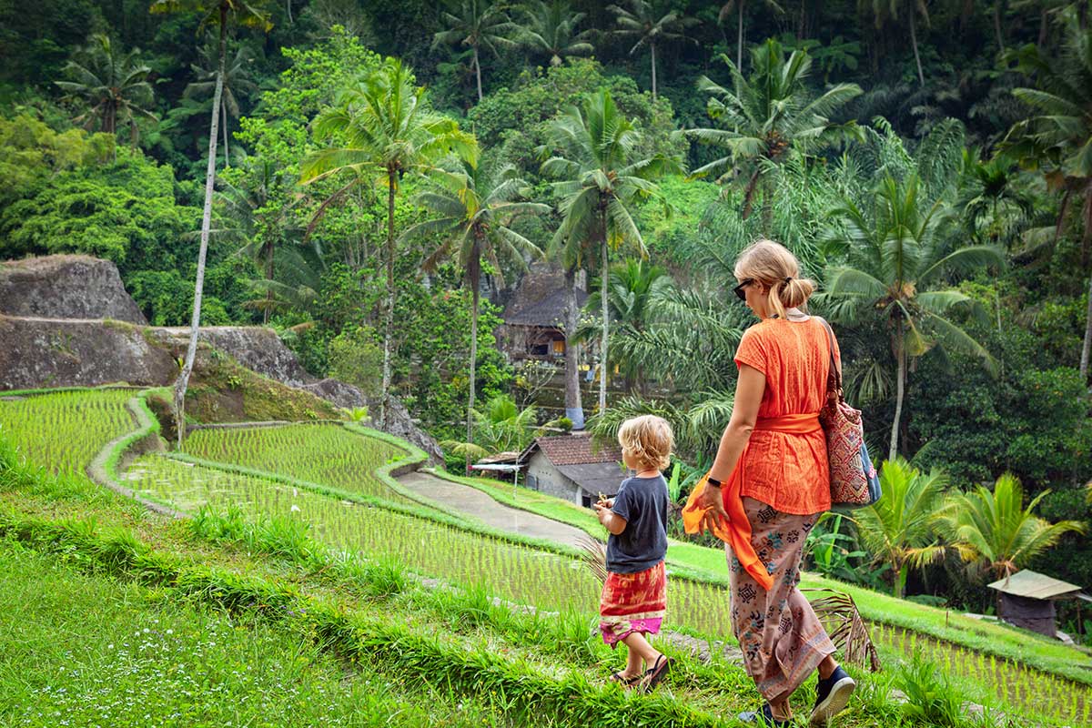 Bali family holiday — kids playing in resort pool with palm trees